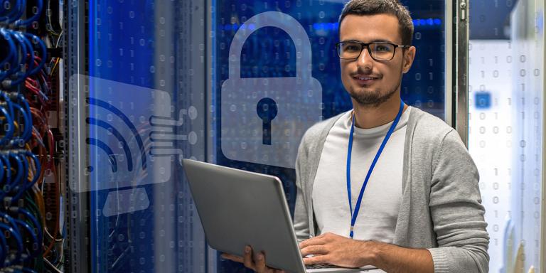 Man with Laptop in Computer Server Room