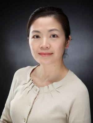 Professional portrait of an East Asian woman in a light-colored cardigan.