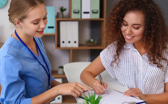 Medical Assistant helping Patient fill out forms